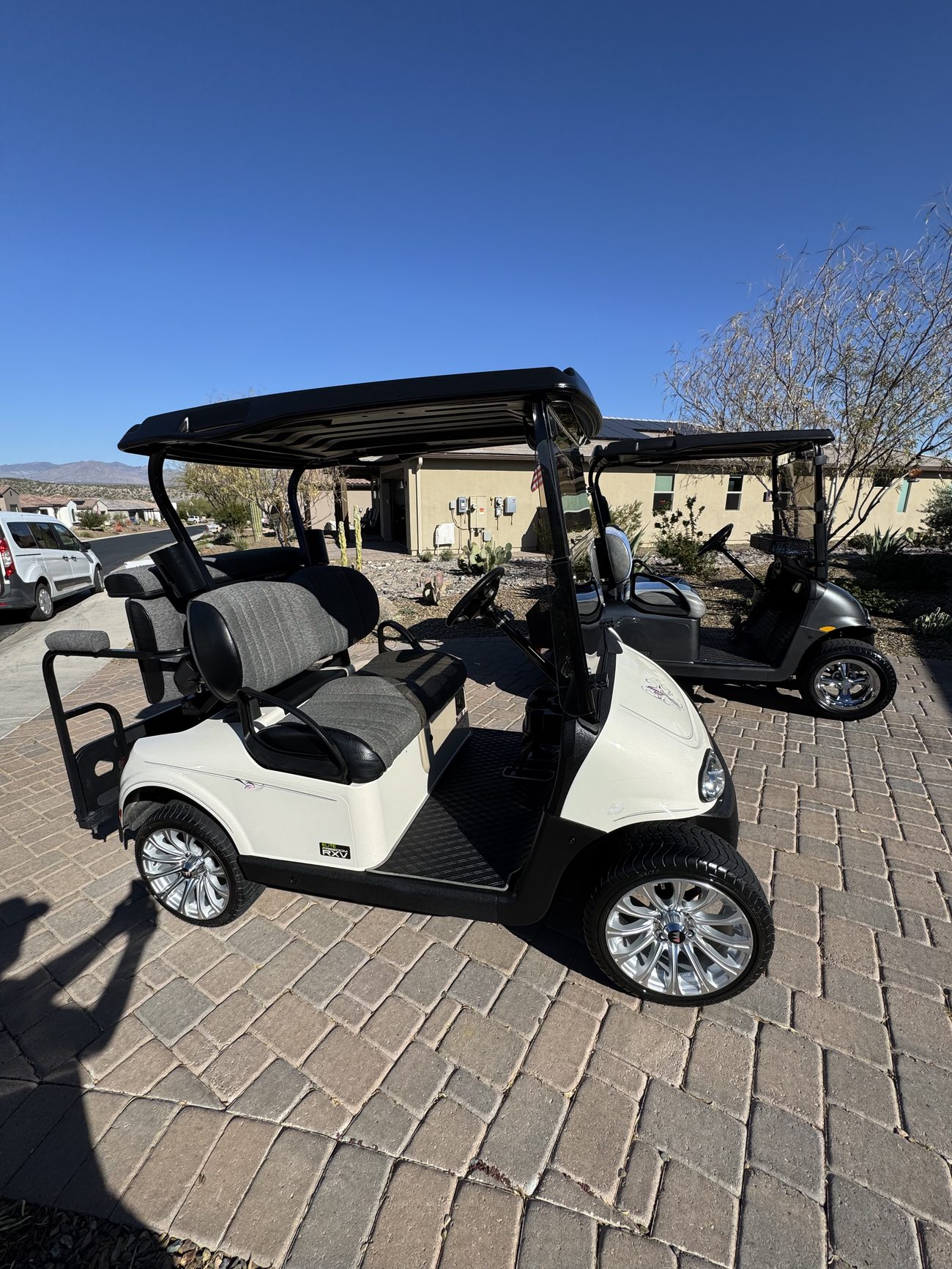 Clean white golf cart detailed and parked on pavers